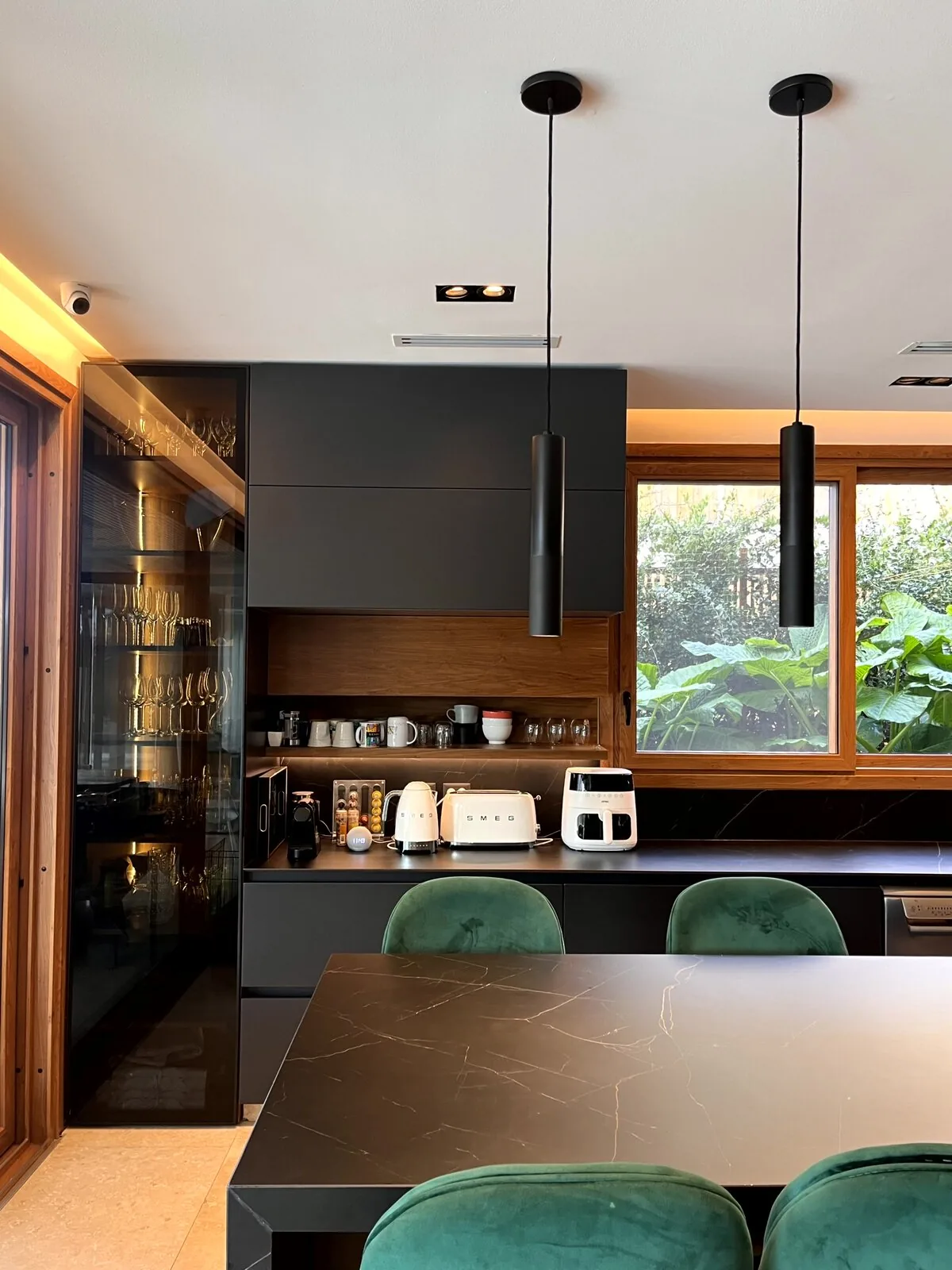 Rinc&oacute;n de caf&eacute; junto a la mesa con sillas de terciopelo verde