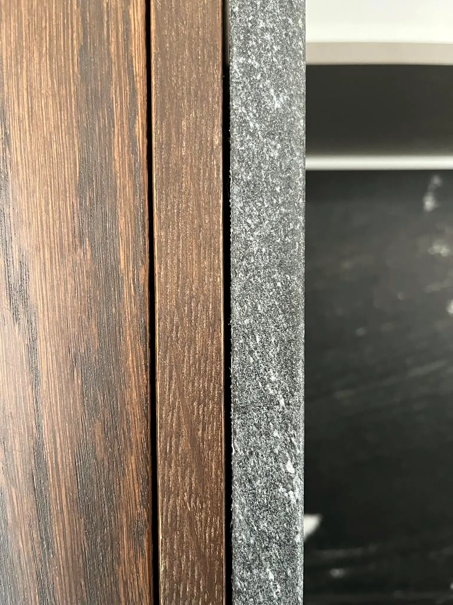 Detalle de un mueble de Formas: el encuentro entre la madera oscura y la piedra