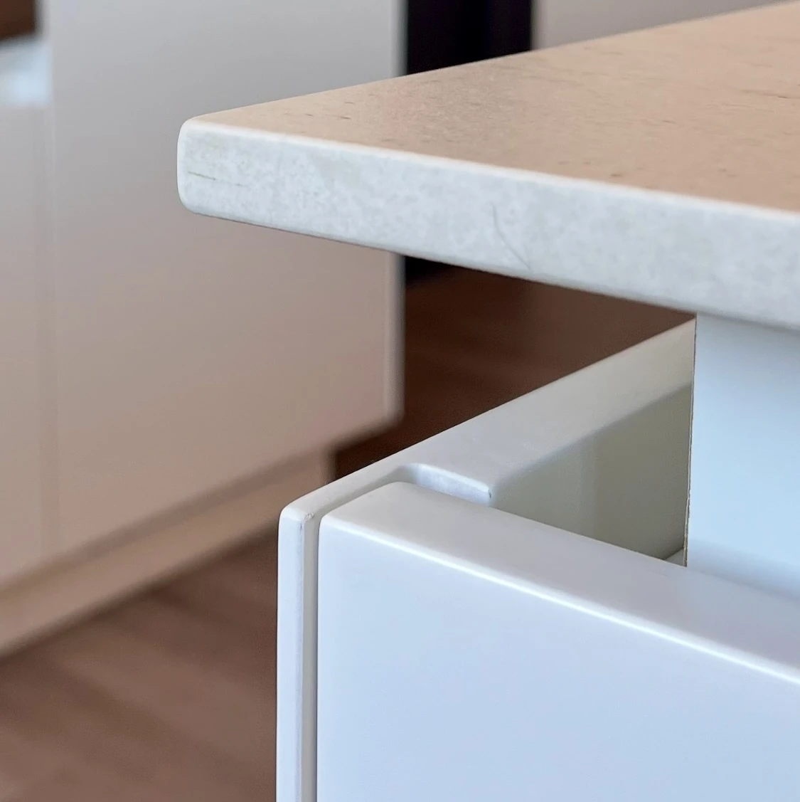 Detalle del encuentro entre la madera blanca y el m&aacute;rmol claro en un mueble de Formas
