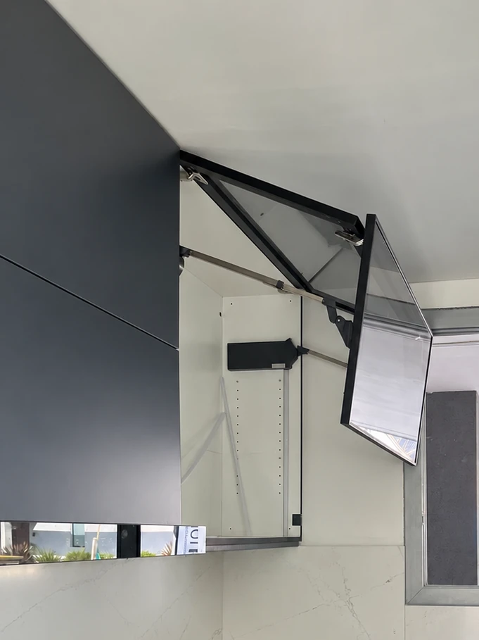 Alacena con puerta elevable abierta y su compás a la vista
